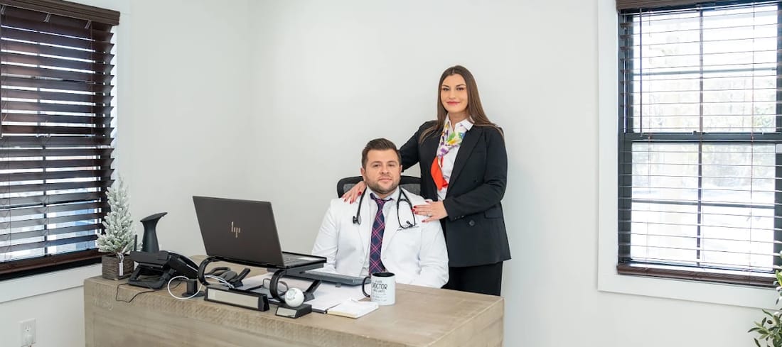 Dr. Kurtovic seated at his desk in the Pleasant Valley office with a member of the practice team