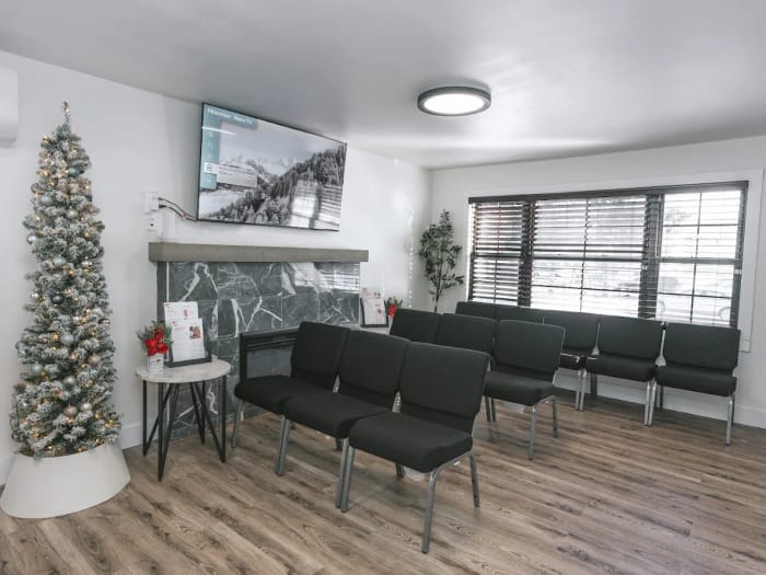 The waiting area with rows of chairs, a fireplace and a wall-mounted television